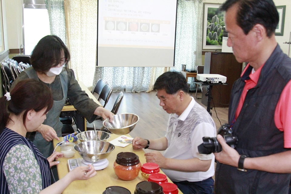 송영선강사로 부터 간편 고추장 만들기 체험에 참가중인 팸투어 기자단이 실습을 하고 있다.
