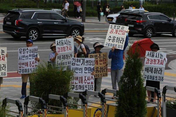 구룡마을 토지주들이 서울시의회와 서울시를 향한 민원에 성의있는 답변을 촉구하는 메가폰 시위를 했다.