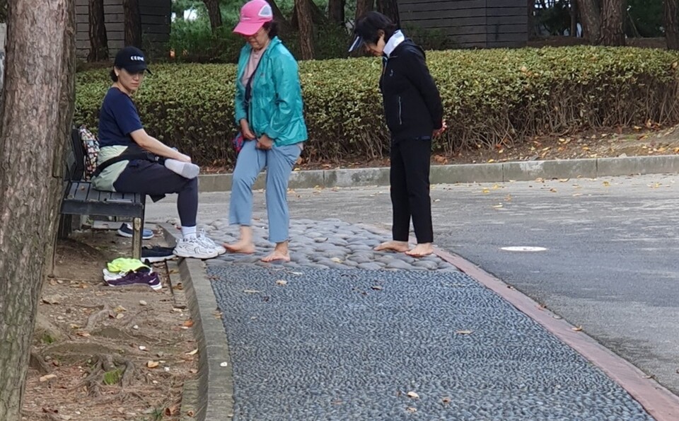 지압보도를 이용한 주민들이 맨발걷기를 마친 뒤 수돗물에 발을 씻기 위해 이동하고 있다. 