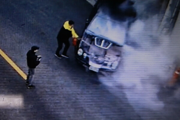 카자흐스탄대사관 직원이 18일 오후 맞은편 주차장에서 빠져 나오던 화염속 차량을 긴급 진화하고 있다.