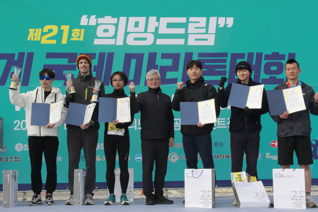 김주현한마협 명예회장과 5km 남자부 우승 입상자들이 시상식을 마친뒤 화이팅을 외치며 기념촬영을 하고 있다.