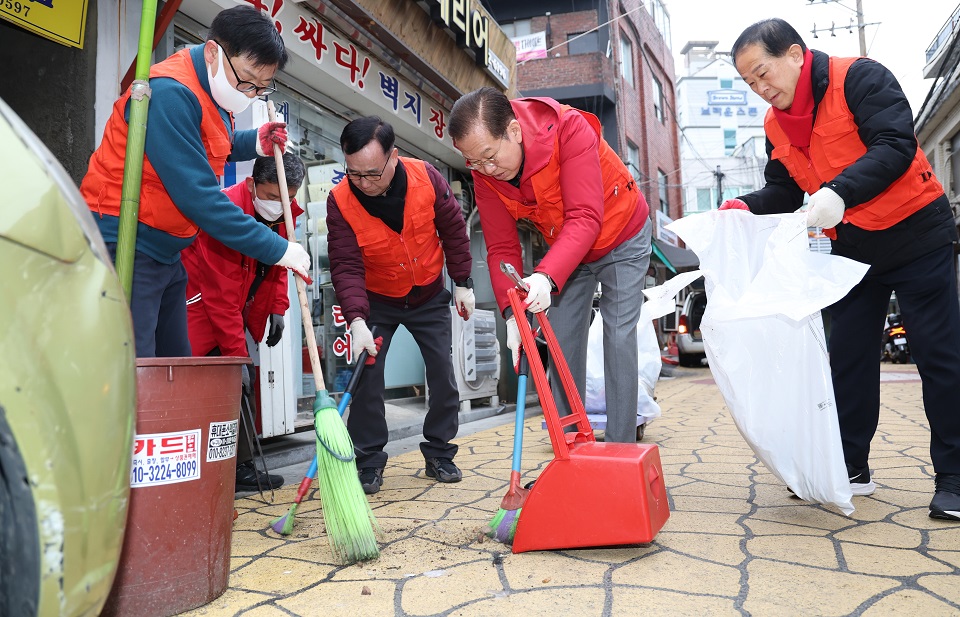 권영세의원과 김용호(오른쪽)시의원, 오천진(왼쪽)구의장,반재선상인회장이 용문시장 거리의 바닥에 널부러진 담배꽁초를 주워 쓰레기 봉투에 수거하고 있다.