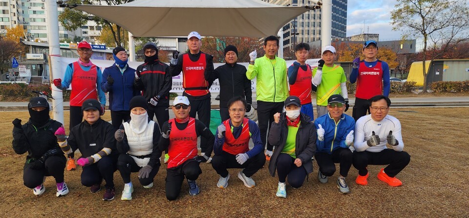 토달 동호회원들이 22일 오전 8시께 러닝 훈련에 앞서 엄지척을 그리며 단체사진 촬영을 하고 있다./사진=토요달리기 제공